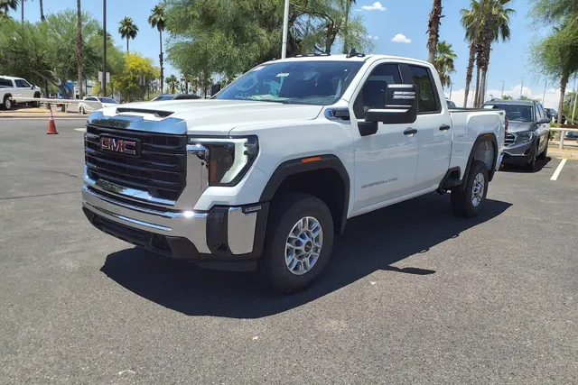 Biały GMC Sierra na placu dealera wśród palm